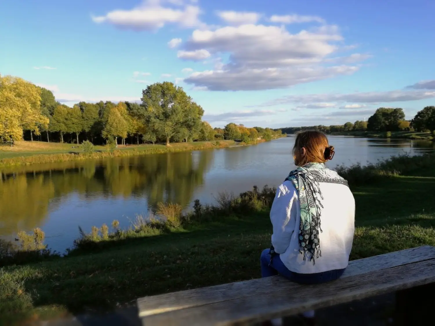 Eine Frau sitzt vor dem See