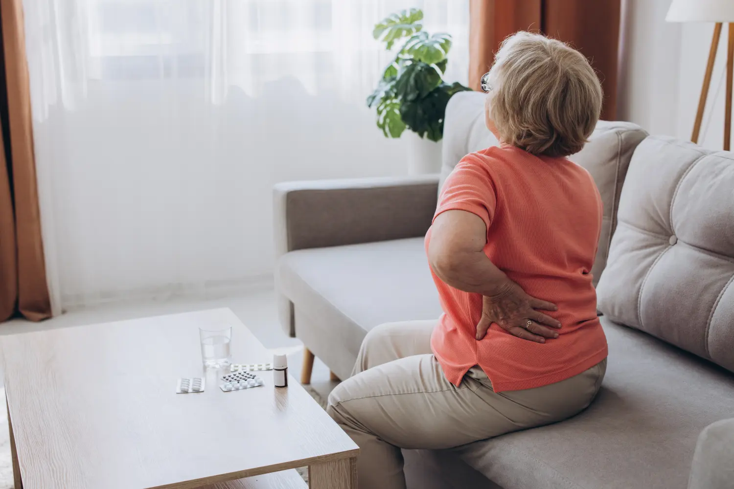 Senior lady feeling muscles pain attack, holding back, having problem with standing up